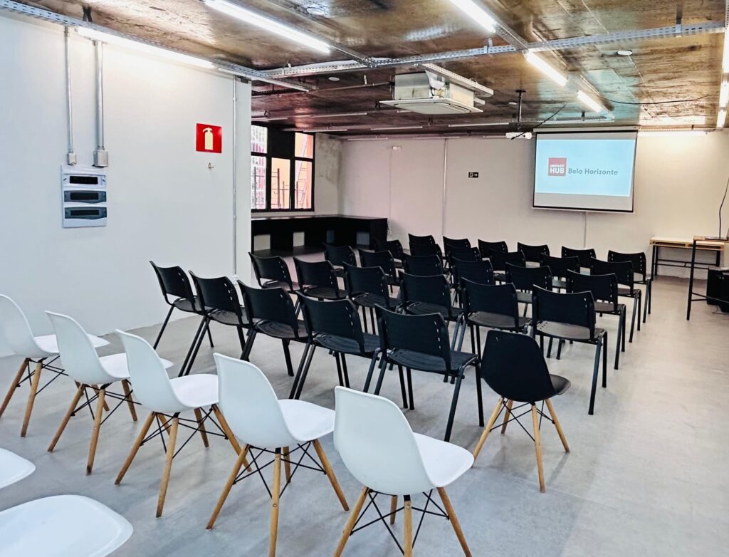 Salão de eventos na Savassi, com cadeiras em formato auditório e projeção.