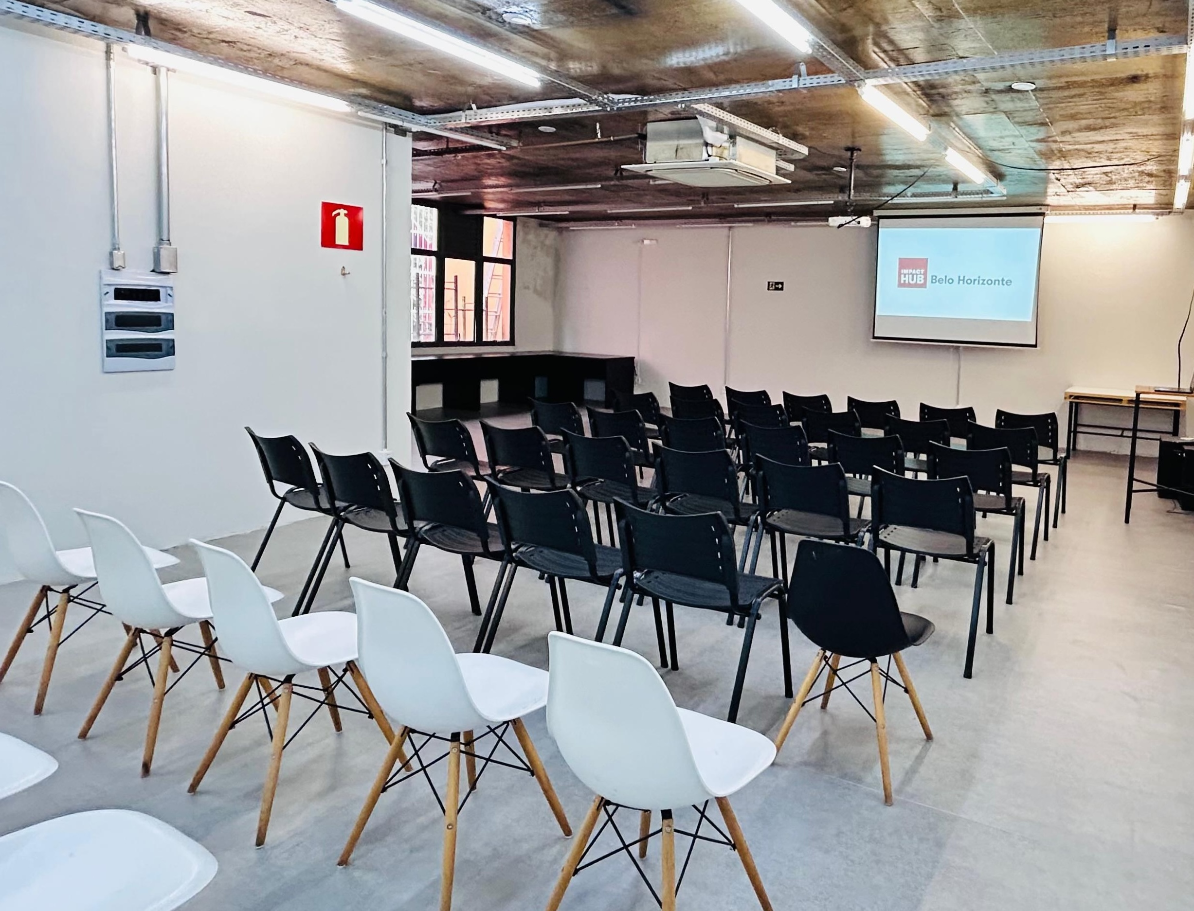 Salão de eventos na Savassi, com cadeiras em formato auditório e projeção.