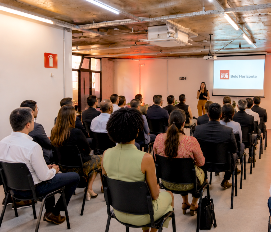 Salão de Eventos na Savassi com pessoas sentadas em cadeiras em formato de auditório com um palestrante