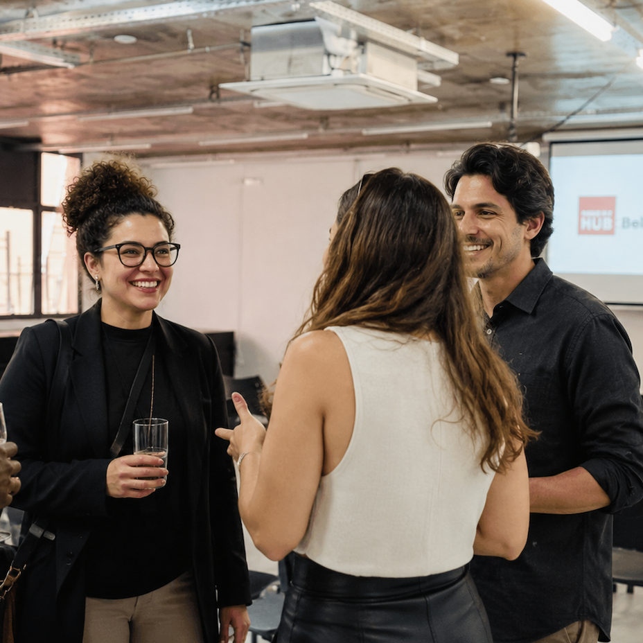 Pessoas conversando em um evento no salão do impact hub